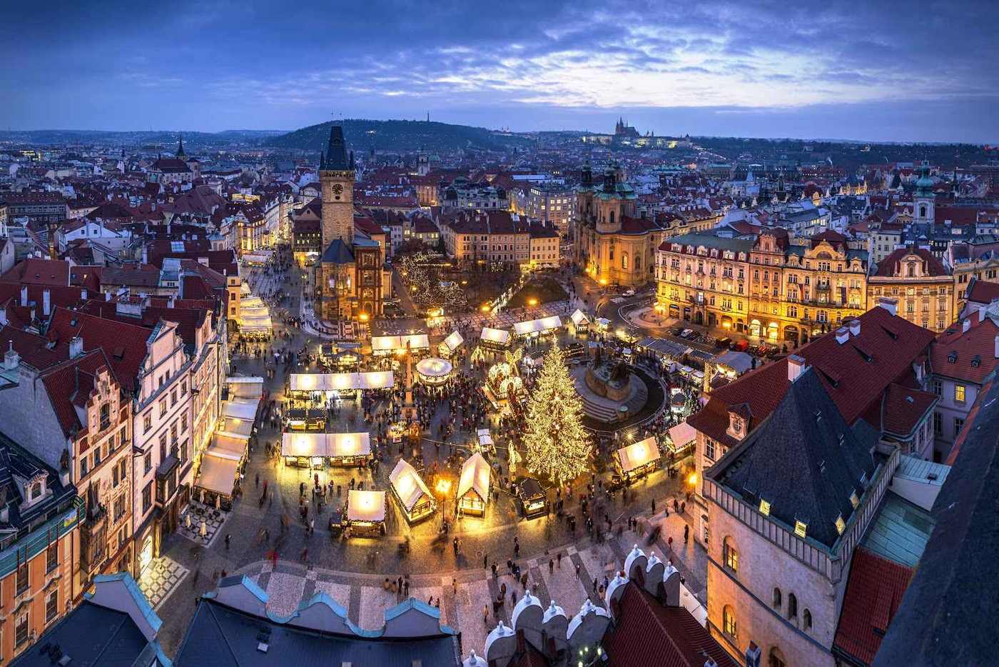 Letecký pohled na osvětlené vánoční trhy na Staroměstském náměstí v Praze s vánočním stromem.